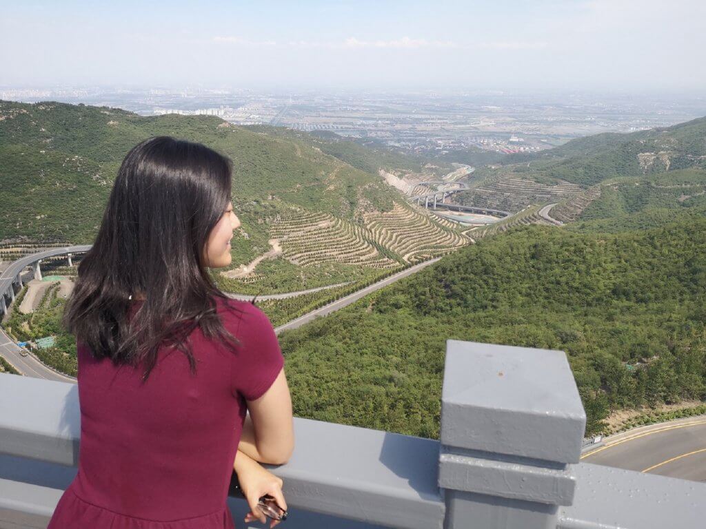 Amy overlooking a green landscape in China