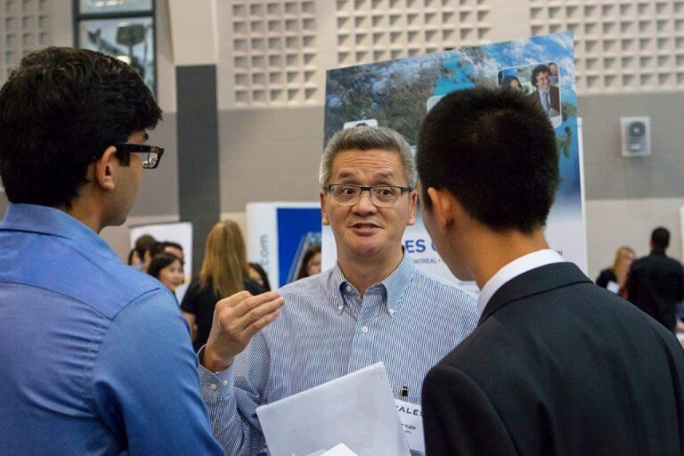 Two students connecting with an employer at Fall Career Fair.