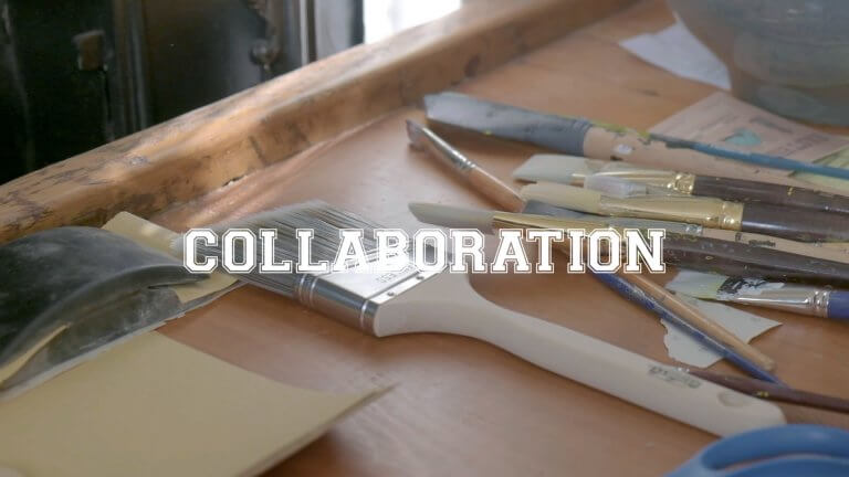 Collaboration. Paintbrushes on desk.