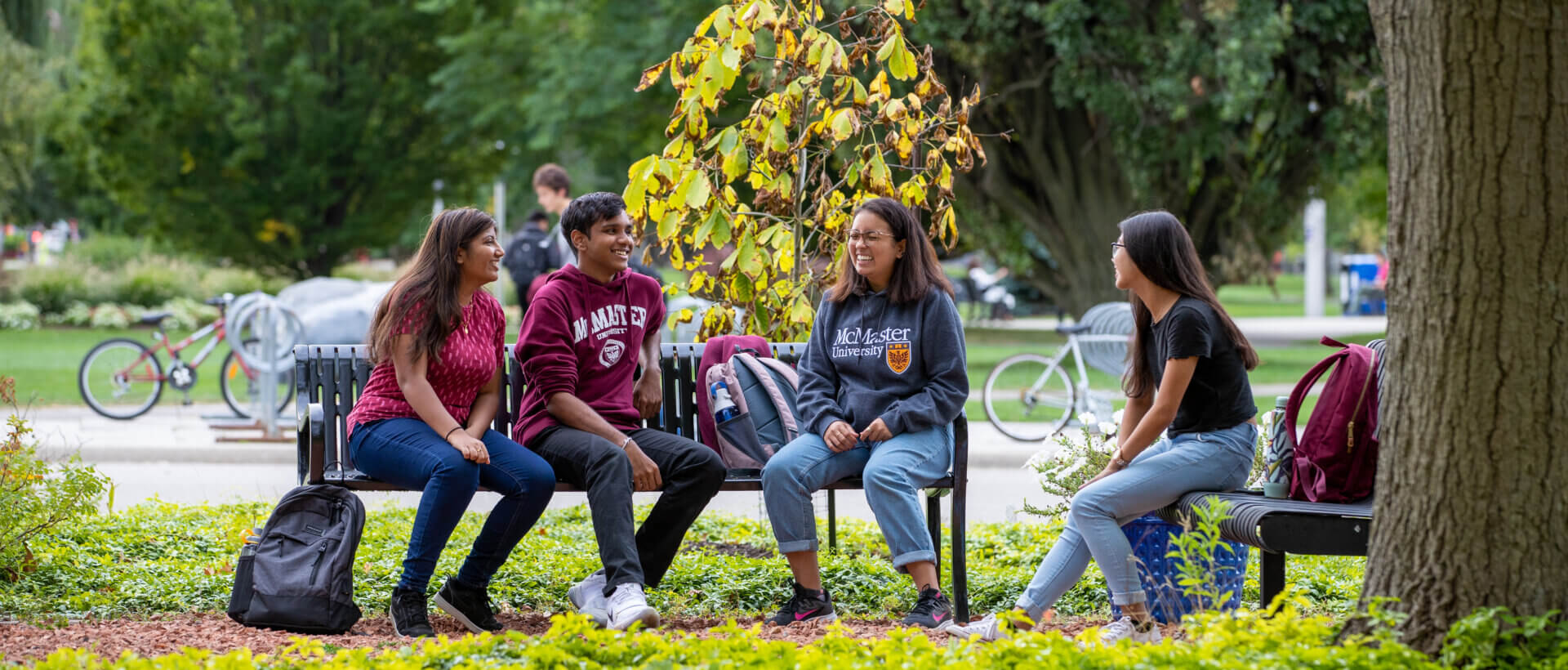 Group of students chatting on campus benches.