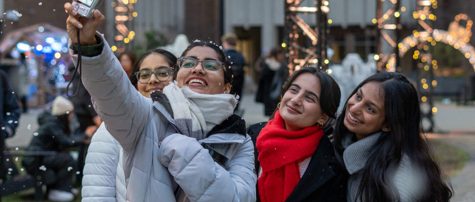 Students taking selfie against festive background