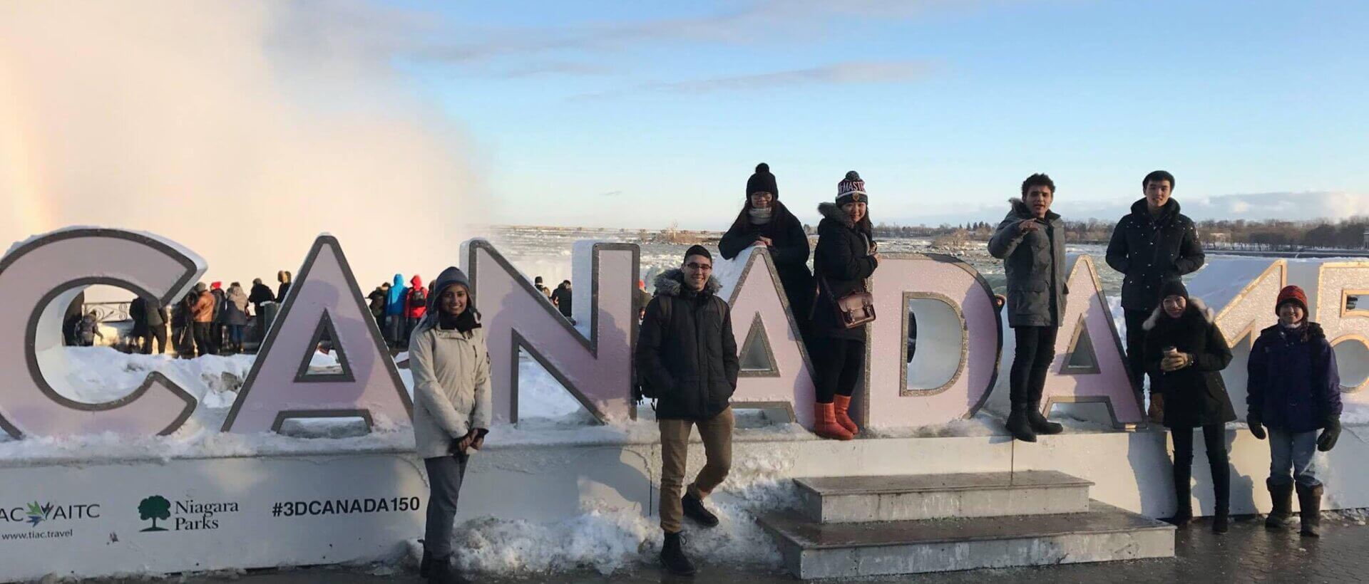Group of students standing by Canada sign in Niagara Falls.