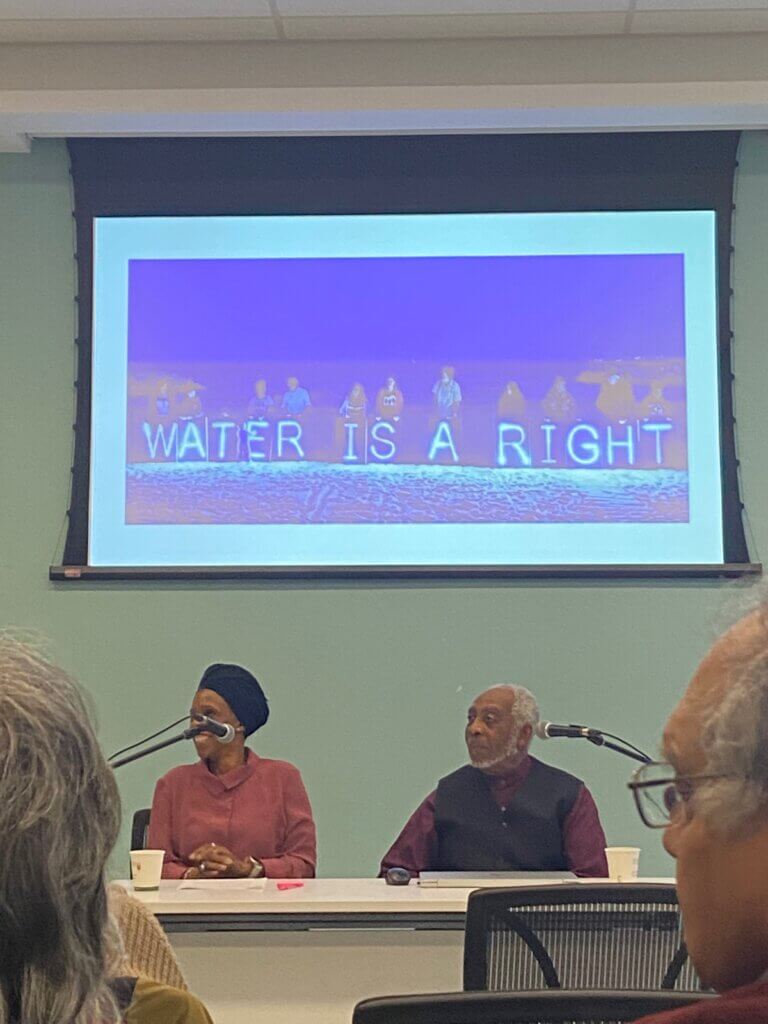 Celeste and Dr. Gary Warner, The projector image says, water is a right.