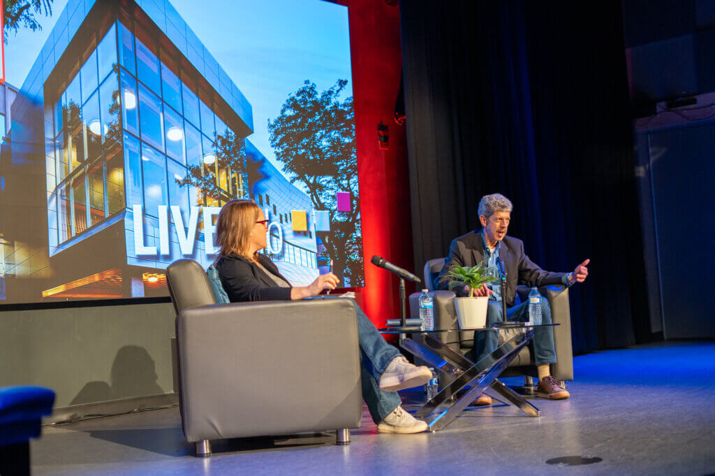 Roma and Rob sitting on stage 